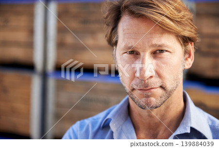 Serious, portrait and mature man by wooden crates for delivery, shipping or exporting business. Industry, storage and professional male person standing by pallets at outdoor distribution warehouse. Serious, portrait and mature man by wooden crates for delivery, shipping or exporting business. Industry, storage and professional male person standing by pallets at outdoor distribution warehouse. 139884039