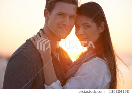 Couple hug, portrait on beach and sunset, nature and travel with bonding for love and commitment outdoor. People with support, trust and loyalty with adventure together for honeymoon or anniversary 139884198
