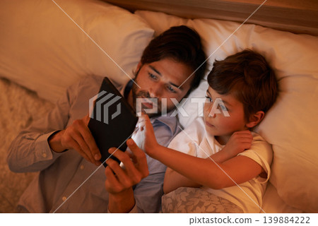 Bedroom, father and son with tablet, evening and family with ebook and connection with social media. Dad, home and boy with tech or bedtime with lights or bonding together with hobby or storytelling 139884222