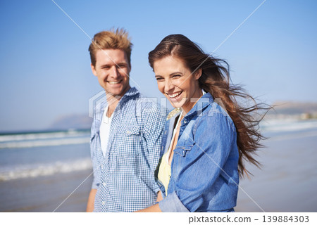 Couple, laugh and walk on beach for romantic date on sunny afternoon with blue sky in Australia. Big smile, man and woman in love for sweet relationship, fun dating and bonding together in summer Couple, laugh and walk on beach for romantic date on sunny afternoon with blue sky in Australia. Big smile, man and woman in love for sweet relationship, fun dating and bonding together in summer 139884303