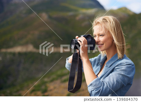 Happy woman, blonde and camera for outdoor photography, picture or sightseeing on mountain. Young female person or journalist with smile for photo, view or memory in natural environment in nature Happy woman, blonde and camera for outdoor photography, picture or sightseeing on mountain. Young female person or journalist with smile for photo, view or memory in natural environment in nature 139884370