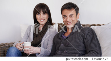Love, portrait and happy couple relax on a sofa with trust support and bonding with morning coffee at home. Smile, face or people in living room with security, safety and chilling together in a house Love, portrait and happy couple relax on a sofa with trust support and bonding with morning coffee at home. Smile, face or people in living room with security, safety and chilling together in a house 139884476