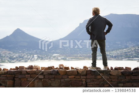 Man, watching mountains and thinking of adventure ideas and inspiration in Cape Town, South Africa. Male person and natural scenery for contemplating, planning and explore on wall with mock up Man, watching mountains and thinking of adventure ideas and inspiration in Cape Town, South Africa. Male person and natural scenery for contemplating, planning and explore on wall with mock up 139884538