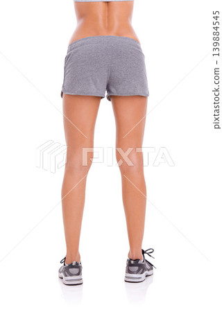 Woman, athlete and legs in studio with wellness for exercise, workout and healthy body with training shoes. Model, person and behind girl with sportswear and shorts for fitness on white background Woman, athlete and legs in studio with wellness for exercise, workout and healthy body with training shoes. Model, person and behind girl with sportswear and shorts for fitness on white background 139884545