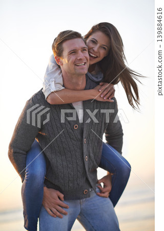 Portrait, piggy back and happy couple on beach at sunset for tropical holiday adventure, relax and bonding together. Love, man and woman on romantic date with ocean, evening sky and travel vacation. Portrait, piggy back and happy couple on beach at sunset for tropical holiday adventure, relax and bonding together. Love, man and woman on romantic date with ocean, evening sky and travel vacation. 139884616