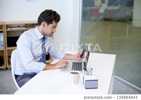 Research, office and businessman with phone, laptop and coffee at startup with technology. Browse, online and business analyst at desk with computer, smartphone and internet connection for networking Research, office and businessman with phone, laptop and coffee at startup with technology. Browse, online and business analyst at desk with computer, smartphone and internet connection for networking 139884843