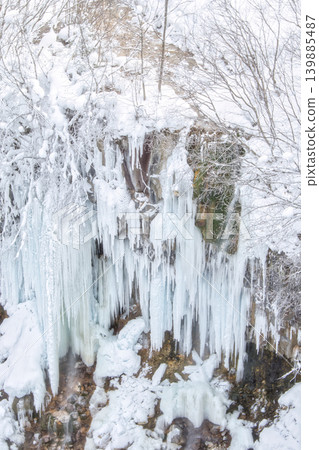 A breathtaking spectacle of dynamic icefalls and gigantic icicles appearing in a winter valley. A breathtaking spectacle of dynamic icefalls and gigantic icicles appearing in a winter valley. 139885487