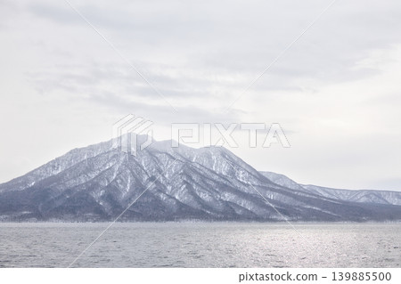 A magnificent, wide-angle view of Lake Shikotsu in winter and the beautifully snow-covered Mt. Fuppushi. 139885500