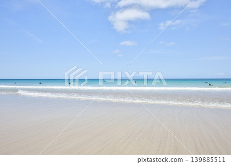 湛藍的天空、碧綠的大海和點綴著衝浪者的白色沙灘，構成了一幅令人嘆為觀止的美景。 139885511