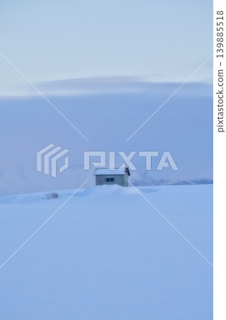 Winter in Biei, Hokkaido: A single cabin stands alone in a vast, snowy landscape. 139885518