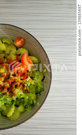 Top view of a fresh vegetable salad bowl on a bright table, healthy lunch routine, organic food nutrition. Top view of a fresh vegetable salad bowl on a bright table, healthy lunch routine, organic food nutrition. 139885697