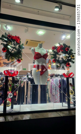Lingerie store window decorated with Christmas wreaths and festive ornaments, retail holiday display, winter shopping Christmas. Lingerie store window decorated with Christmas wreaths and festive ornaments, retail holiday display, winter shopping Christmas. 139885731
