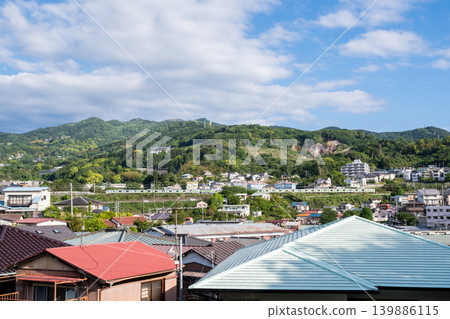[Tokaido Main Line] An early morning local train running through a town along the coast. 139886115