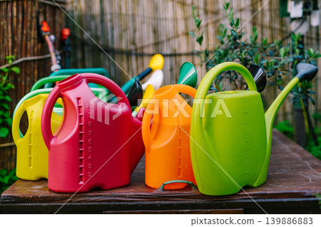 Colorful watering cans in the garden 139886883