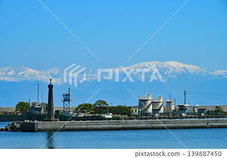 Toyama Prefecture, Toyama Bay, Himi Fishing Port, inside the harbor, snow-capped Tateyama mountain range. 139887450
