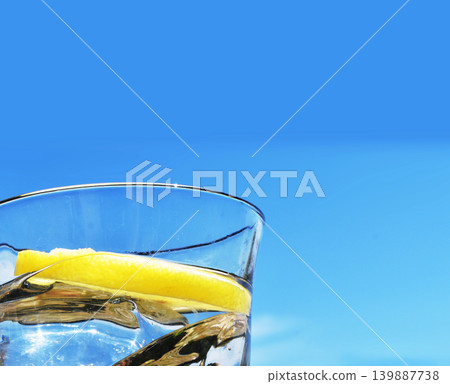 Blue sky and a glass of mineral water with lemon. Blue sky and a glass of mineral water with lemon. 139887738