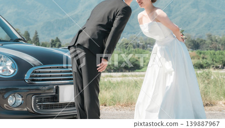 Bride and groom taking wedding photos with their beloved car (convertible) 139887967
