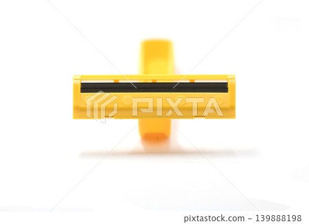 A Close Up Shot of a Yellow Plastic Disposable Razor Showing Sharp Twin Blades Isolated on a Soft Clean White Background with Copy Space A Close Up Shot of a Yellow Plastic Disposable Razor Showing Sharp Twin Blades Isolated on a Soft Clean White Background with Copy Space 139888198