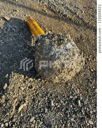 一根黃色路障柱和混凝土基座倒在地上。 一根黃色路障柱和混凝土基座倒在地上。 139888831