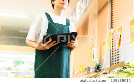 A male employee operates a tablet. 139889015