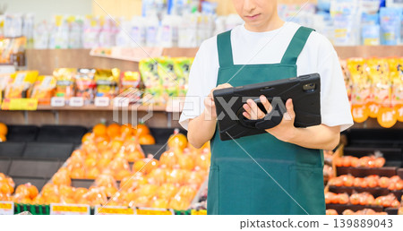 Male clerk working at the supermarket Male clerk working at the supermarket 139889043