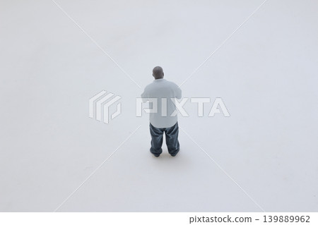 Miniature standing figure wearing chain gesturing pose 139889962