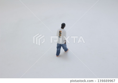 Miniature figure walking away isolated on white Miniature figure walking away isolated on white 139889967
