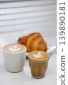 Cup of hot milk piccolo latte coffee and hot cappucino with croissant on white table. 139890181