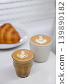 Cup of hot milk piccolo latte coffee and hot cappucino with croissant on white table. 139890182