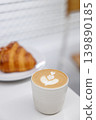 Cup of hot milk Cappuccino with croissant on white table. 139890185