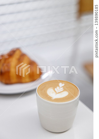 Cup of hot milk Cappuccino with croissant on white table. Cup of hot milk Cappuccino with croissant on white table. 139890185