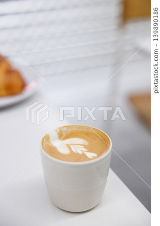 Cup of hot milk Cappuccino with croissant on white table. Cup of hot milk Cappuccino with croissant on white table. 139890186