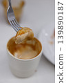 Piece of croissant dipping in a cup of hot Cappuccino. 139890187