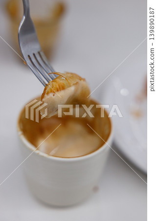 Piece of croissant dipping in a cup of hot Cappuccino. Piece of croissant dipping in a cup of hot Cappuccino. 139890187