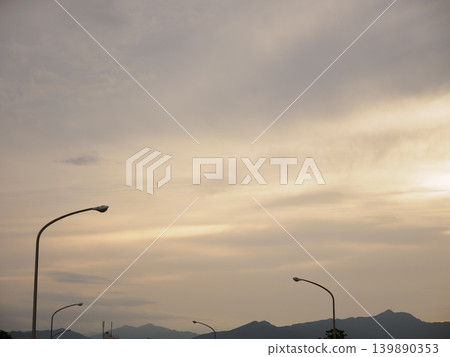 The contrast between the cloudy twilight sky and the streetlights 139890353