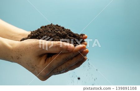 Hands holding fertile soil against blue sky,Agriculture, environmental sustainability Hands holding fertile soil against blue sky,Agriculture, environmental sustainability 139891108