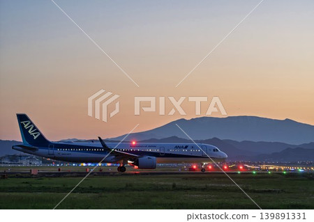 Sendai Airport at dusk, with a taxiing airplane and the Zao mountain range in the background, Natori City, Miyagi Prefecture. Sendai Airport at dusk, with a taxiing airplane and the Zao mountain range in the background, Natori City, Miyagi Prefecture. 139891331