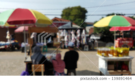 A blurry view of a traditional market with colorful umbrellas. A blurry view of a traditional market with colorful umbrellas. 139891464