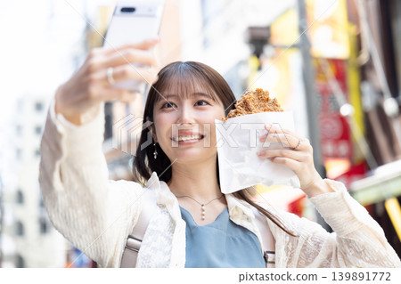 一位女士在橫濱中華街享用街頭小吃 一位女士在橫濱中華街享用街頭小吃 139891772