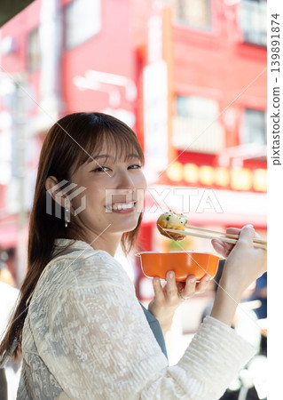 一位女士在橫濱中華街享用街頭小吃 139891874