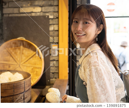 一位女士在橫濱中華街享用街頭小吃 一位女士在橫濱中華街享用街頭小吃 139891875