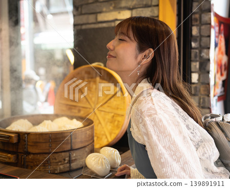 A woman enjoying street food in Yokohama Chinatown A woman enjoying street food in Yokohama Chinatown 139891911