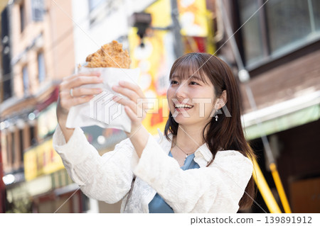 A woman enjoying street food in Yokohama Chinatown A woman enjoying street food in Yokohama Chinatown 139891912