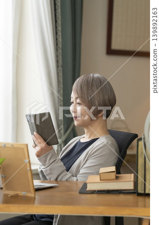 Senior woman working remotely from her home office Senior woman working remotely from her home office 139892163