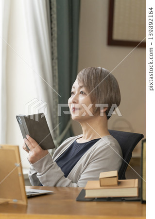 Senior woman working remotely from her home office Senior woman working remotely from her home office 139892164