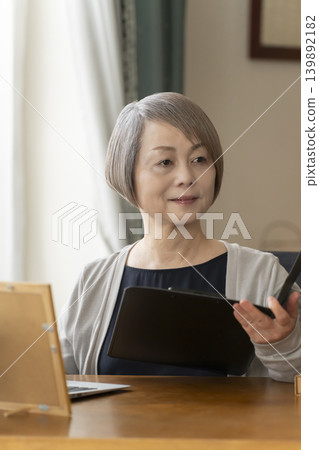 Senior woman working remotely from her home office Senior woman working remotely from her home office 139892182