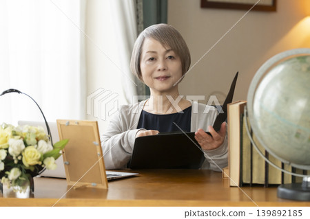 Senior woman working remotely from her home office Senior woman working remotely from her home office 139892185