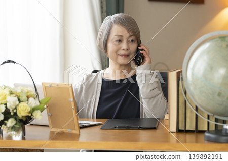 Senior woman working remotely from her home office Senior woman working remotely from her home office 139892191