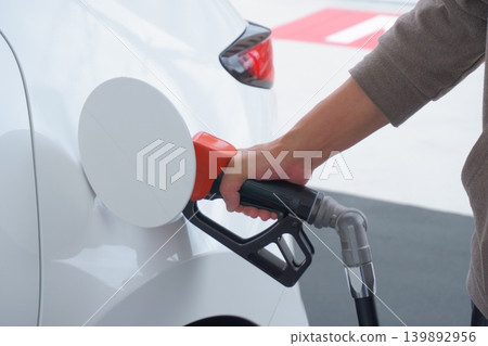 The hand that fills up the gas tank at the gas station The hand that fills up the gas tank at the gas station 139892956