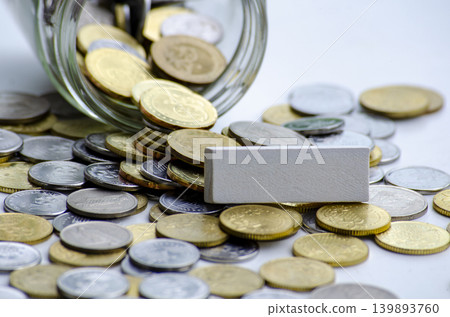 Mixed coins beside white blocks showing savings goals and targets Mixed coins beside white blocks showing savings goals and targets 139893760